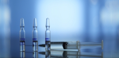 Several ampoules in front of a blue background